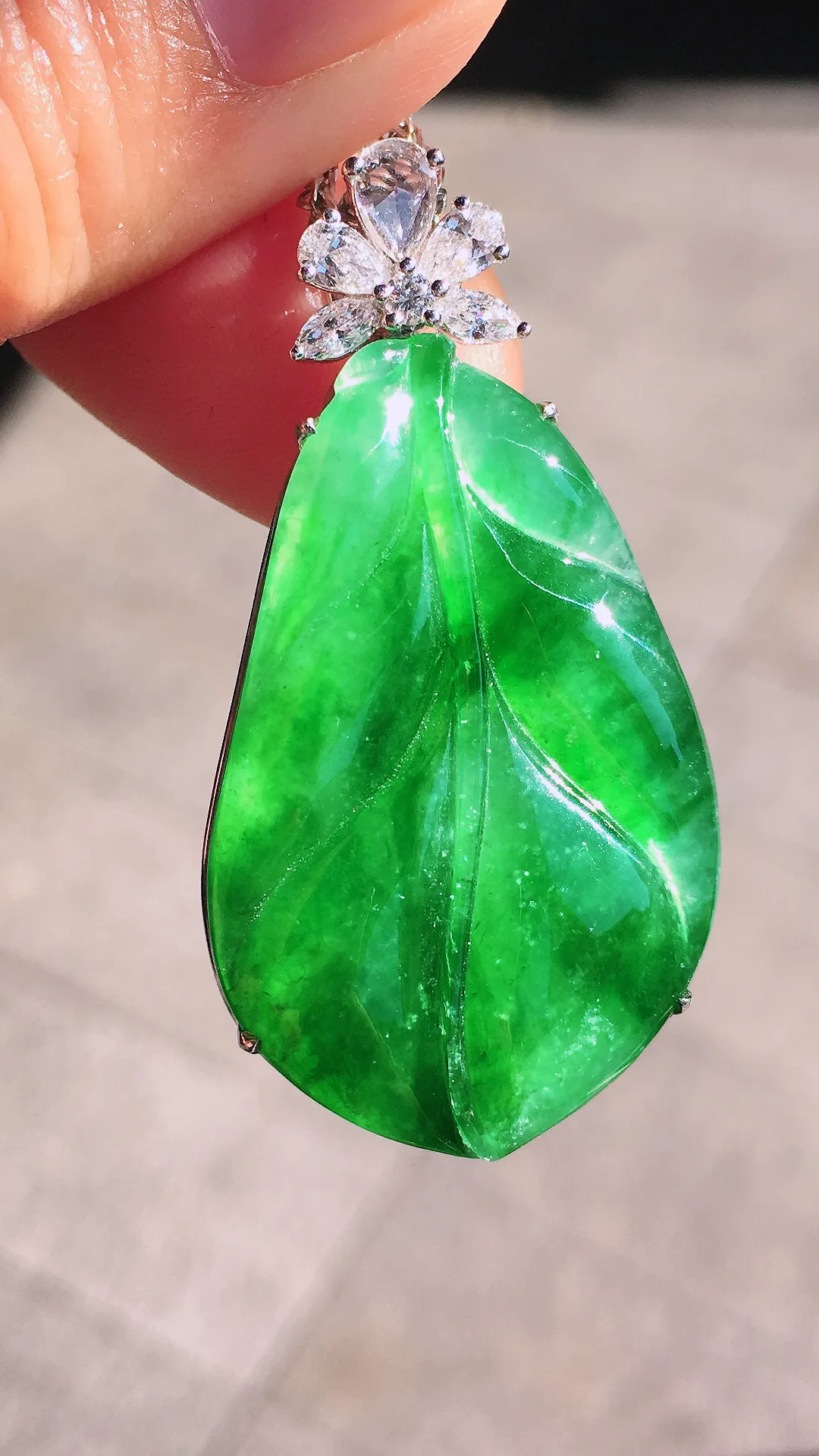 阳绿玉叶吊坠，色泽均匀艳丽，玉质细腻，荧光感超
强，饱满圆润，尽显优雅气质，18k
金豪华镶嵌