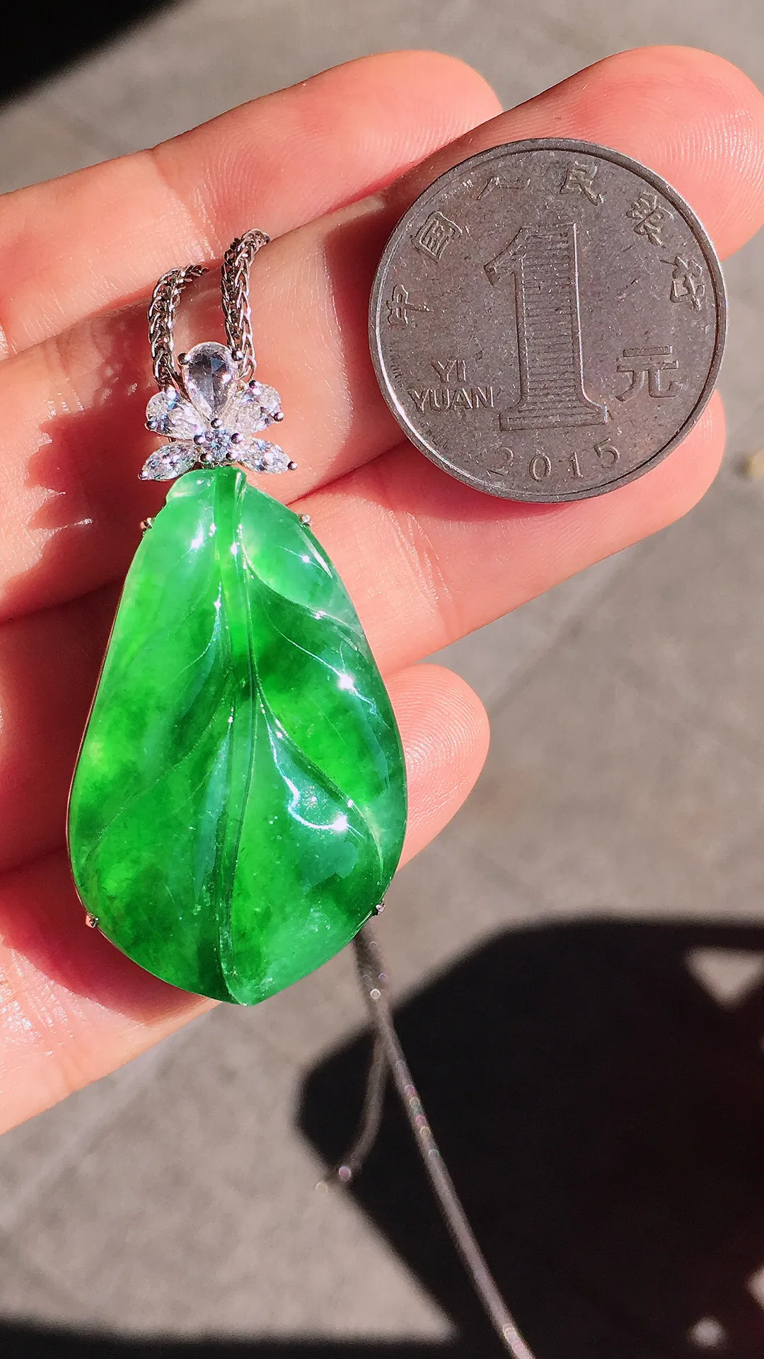 阳绿玉叶吊坠，色泽均匀艳丽，玉质细腻，荧光感超
强，饱满圆润，尽显优雅气质，18k
金豪华镶嵌