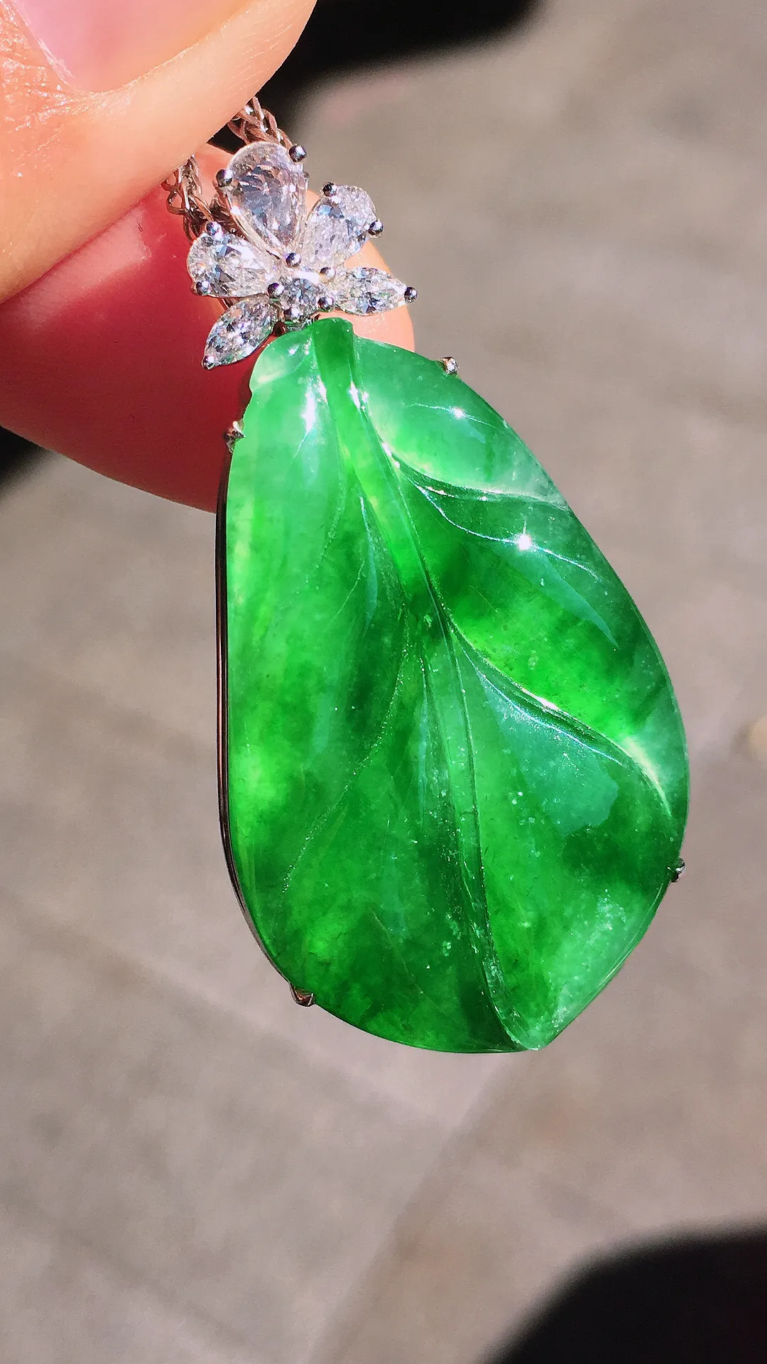 阳绿玉叶吊坠，色泽均匀艳丽，玉质细腻，荧光感超
强，饱满圆润，尽显优雅气质，18k
金豪华镶嵌