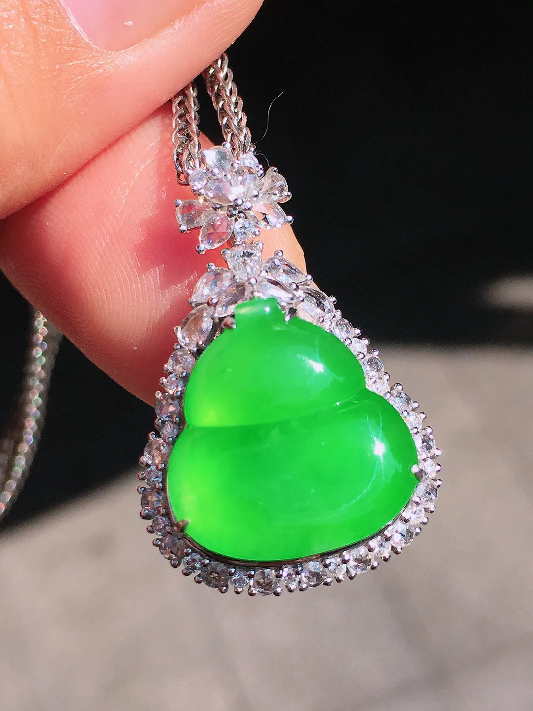 阳绿葫芦吊坠，色泽均匀艳丽，玉质细腻，荧光感超
强，饱满圆润，尽显优雅气质，18k
金豪华镶嵌