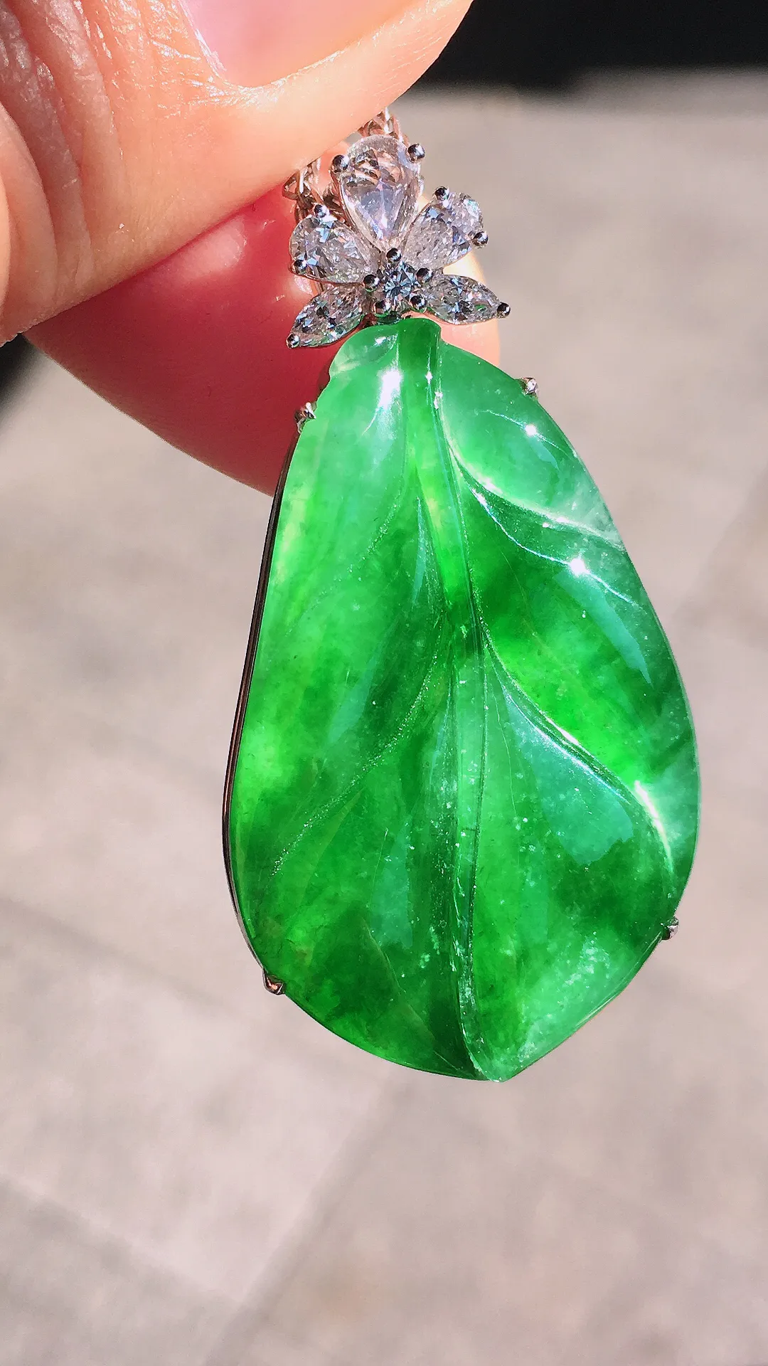 阳绿玉叶吊坠，色泽均匀艳丽，玉质细腻，荧光感超
强，饱满圆润，尽显优雅气质，18k
金豪华镶嵌