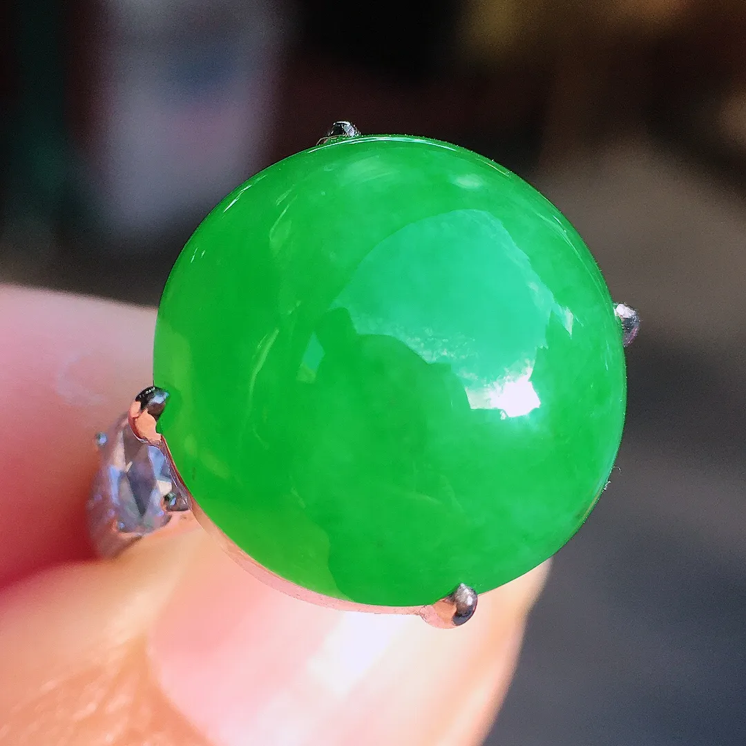 阳绿蛋面戒指，色泽均匀艳丽，玉质细腻，荧光感超
强，饱满圆润，尽显优雅气质，18k
金豪华镶嵌