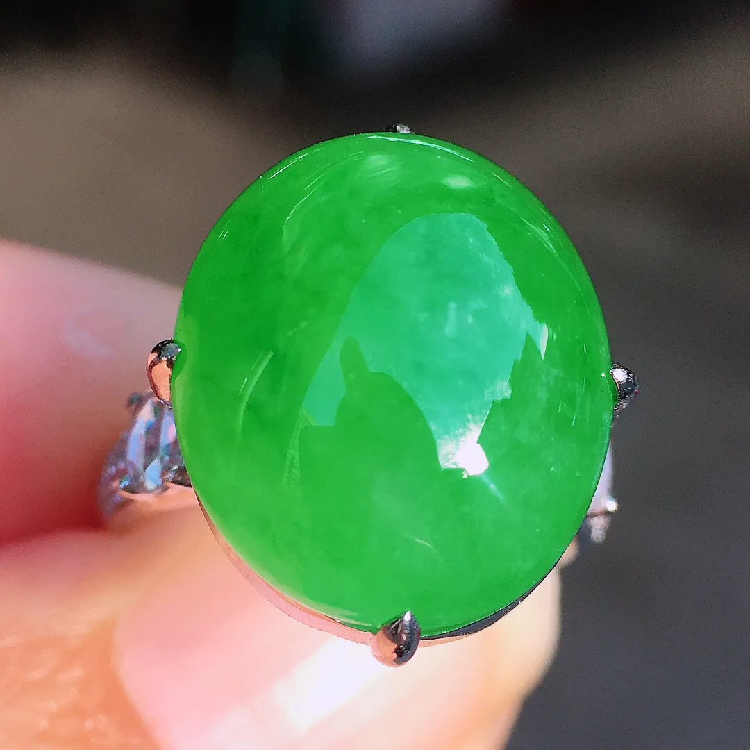 阳绿蛋面戒指，色泽均匀艳丽，玉质细腻，荧光感超
强，饱满圆润，尽显优雅气质，18k
金豪华镶嵌