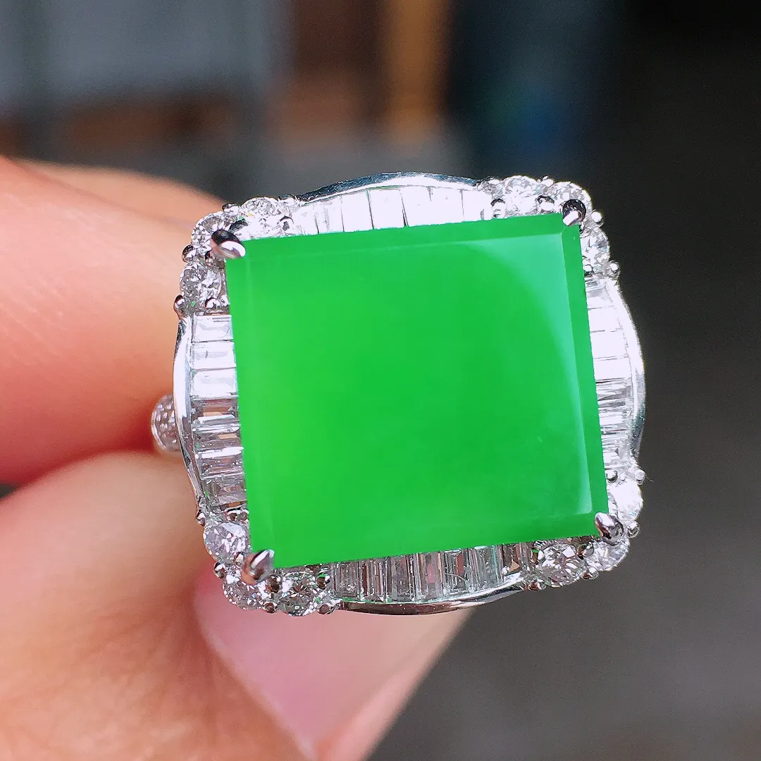 阳绿马鞍戒指，色泽均匀艳丽，玉质细腻，荧光感超
强，饱满圆润，尽显优雅气质，18k
金豪华镶嵌