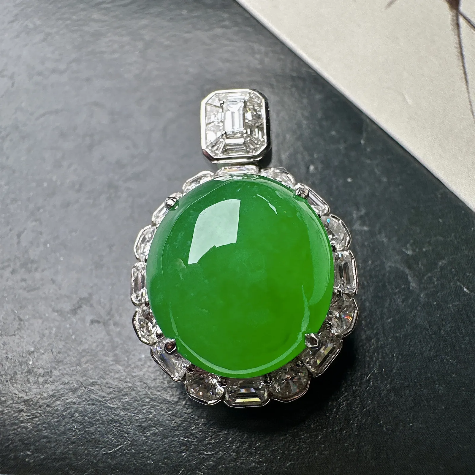 【冰种满绿蛋面吊坠】质地细腻，冰润起光，胶感强烈，冰感明显。18K金钻精美镶嵌，裸石尺寸16.2*1