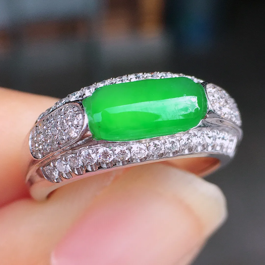 阳绿马鞍戒指，色泽均匀艳丽，玉质细腻，荧光感超
强，饱满圆润，尽显优雅气质，18k
金豪华镶嵌