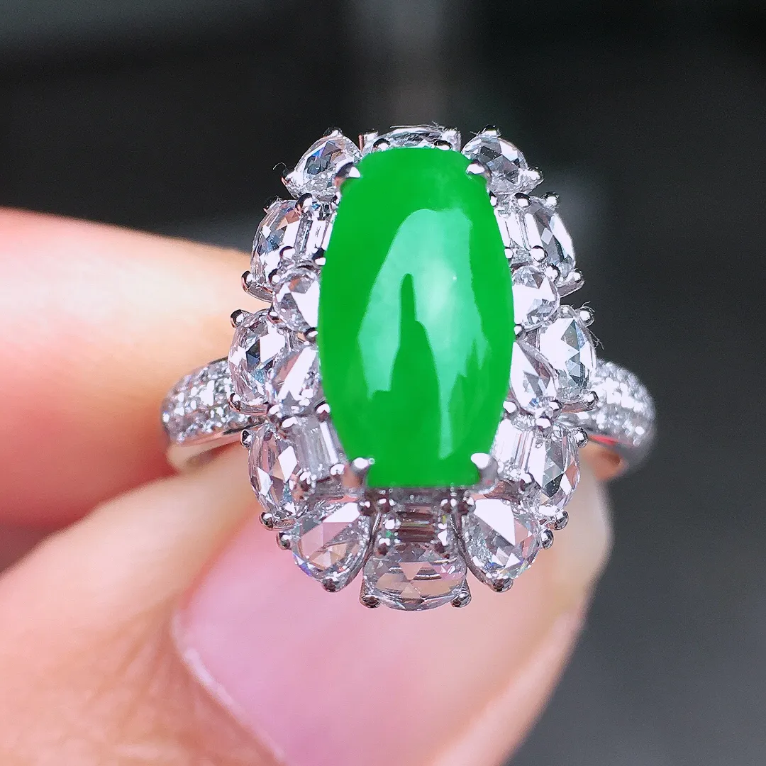 阳绿马鞍戒指，色泽均匀艳丽，玉质细腻，荧光感超
强，饱满圆润，尽显优雅气质，18k
金豪华镶嵌