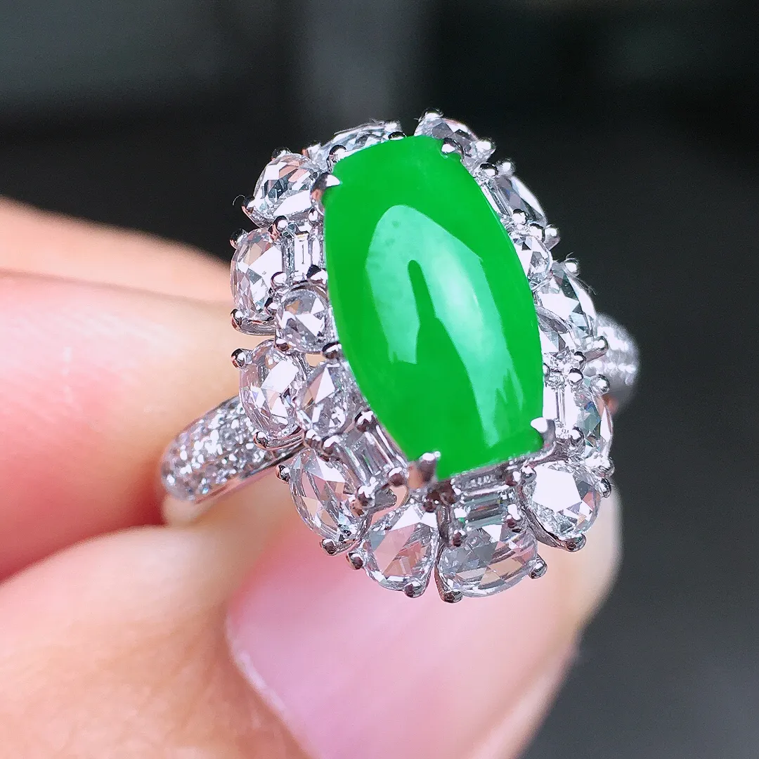 阳绿马鞍戒指，色泽均匀艳丽，玉质细腻，荧光感超
强，饱满圆润，尽显优雅气质，18k
金豪华镶嵌