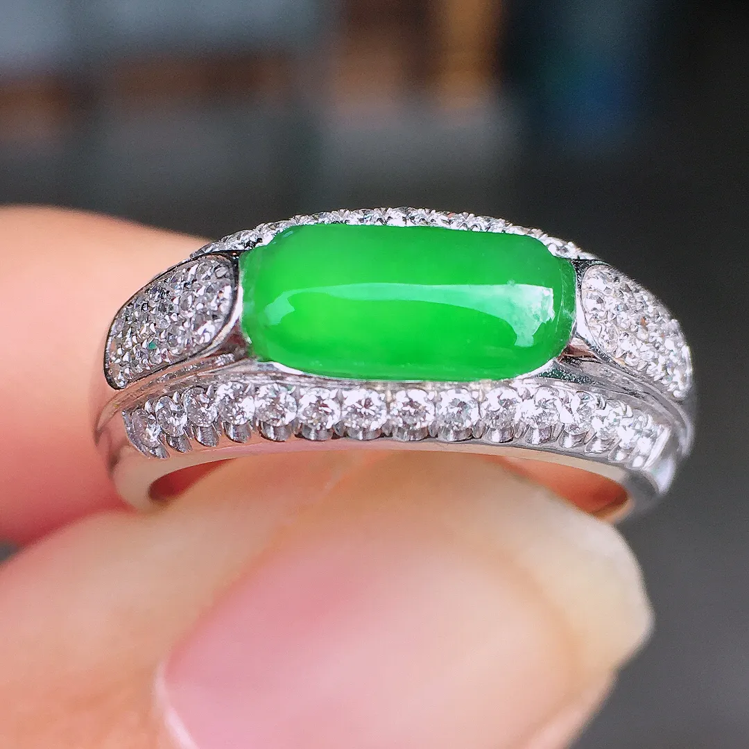 阳绿马鞍戒指，色泽均匀艳丽，玉质细腻，荧光感超
强，饱满圆润，尽显优雅气质，18k
金豪华镶嵌