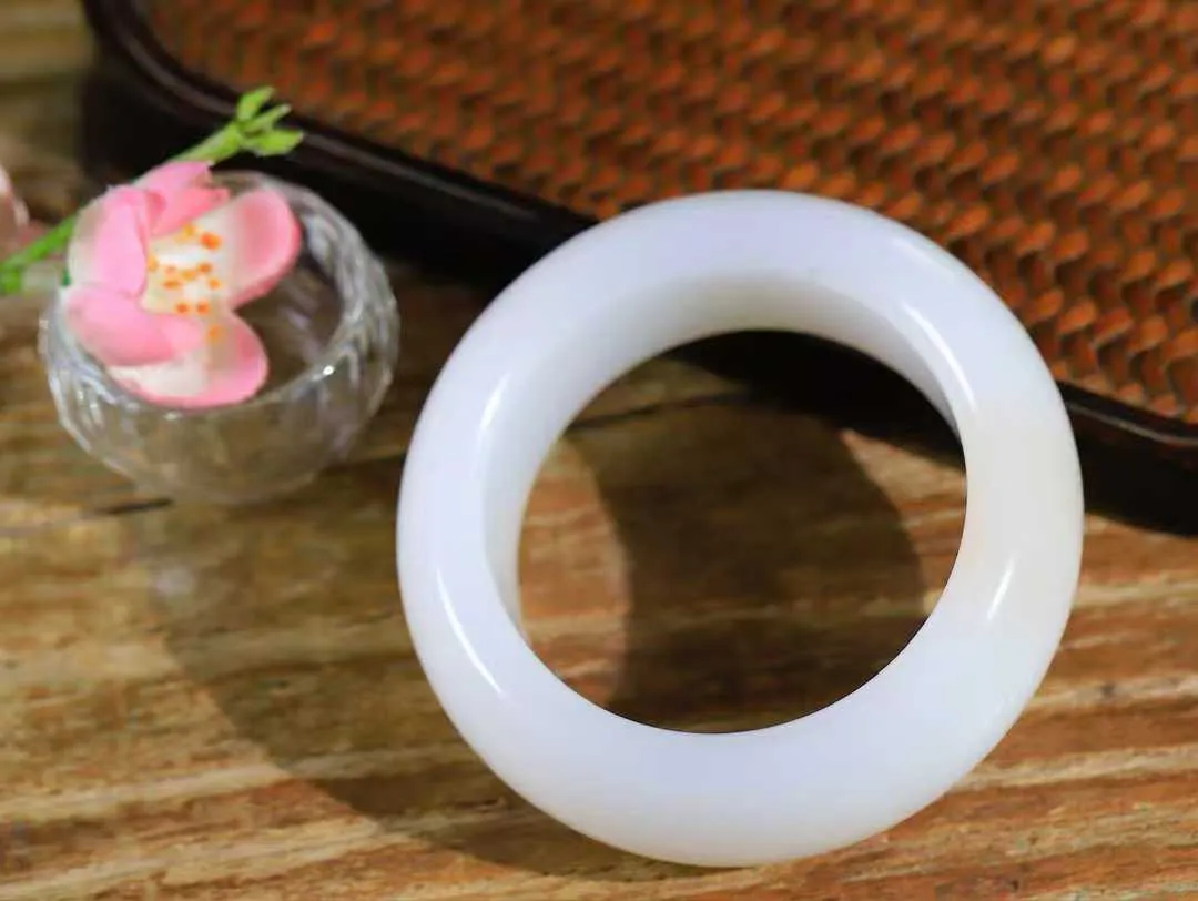 （柔情似水.手镯）

收藏级臻品和田玉白玉带藕粉手镯，玉质温润细腻，镯型饱满圆润，优雅知性，姽婳于幽静兮，又婆娑乎人间，经典款型，古朴典雅。极具灵性，腕间风情，风姿卓越。 重129.6克    内径51mm 尺寸24-11.5mm   781141941T