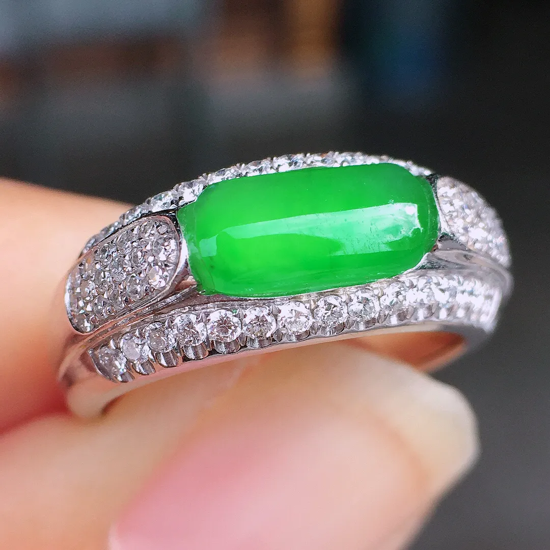 阳绿马鞍戒指，色泽均匀艳丽，玉质细腻，荧光感超
强，饱满圆润，尽显优雅气质，18k
金豪华镶嵌