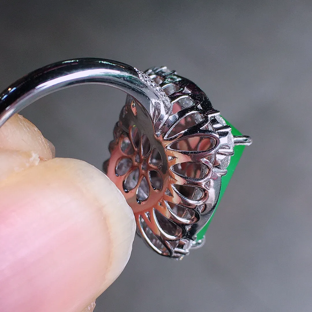 阳绿马鞍戒指，色泽均匀艳丽，玉质细腻，荧光感超
强，饱满圆润，尽显优雅气质，18k
金豪华镶嵌