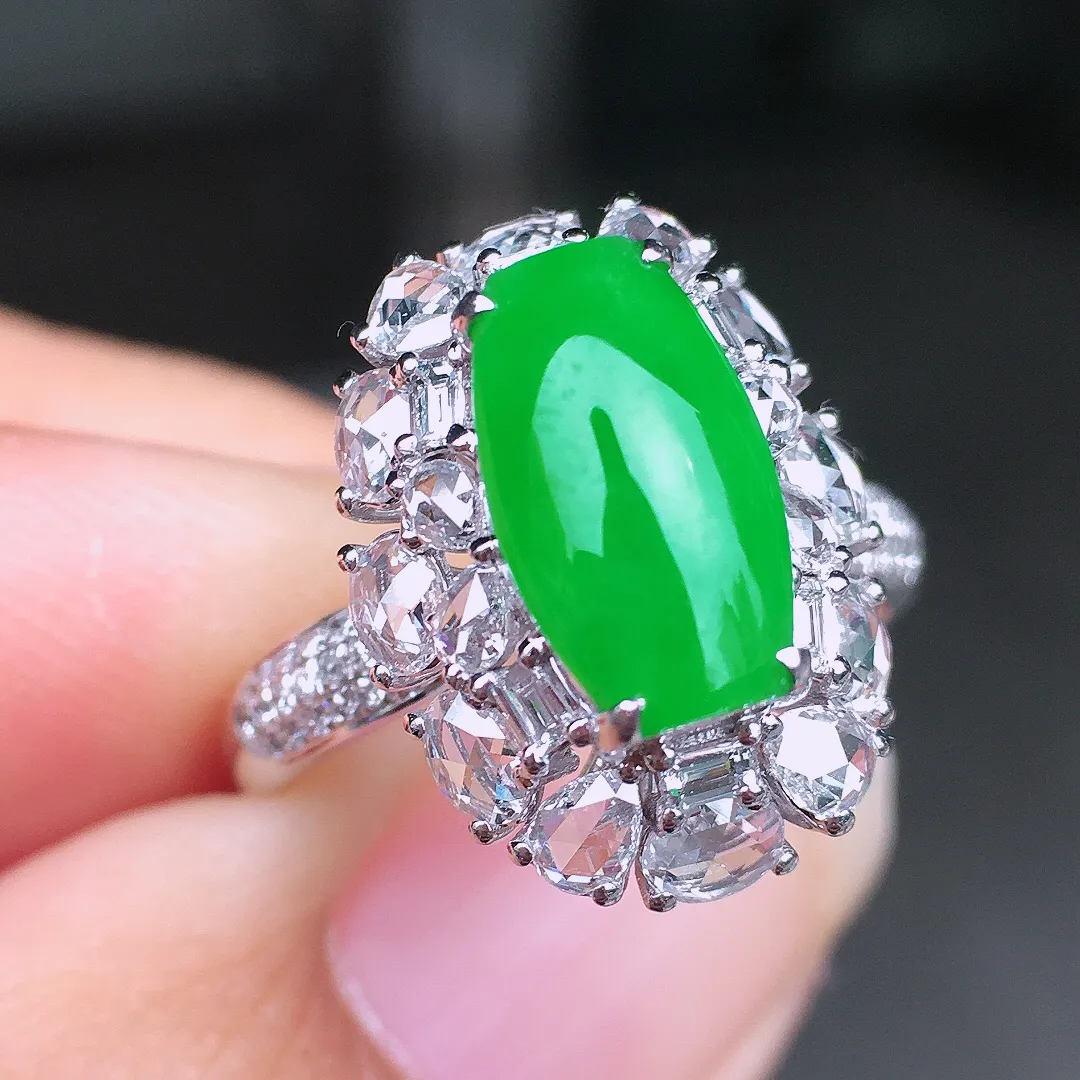 阳绿马鞍戒指，色泽均匀艳丽，玉质细腻，荧光感超
强，饱满圆润，尽显优雅气质，18k
金豪华镶嵌