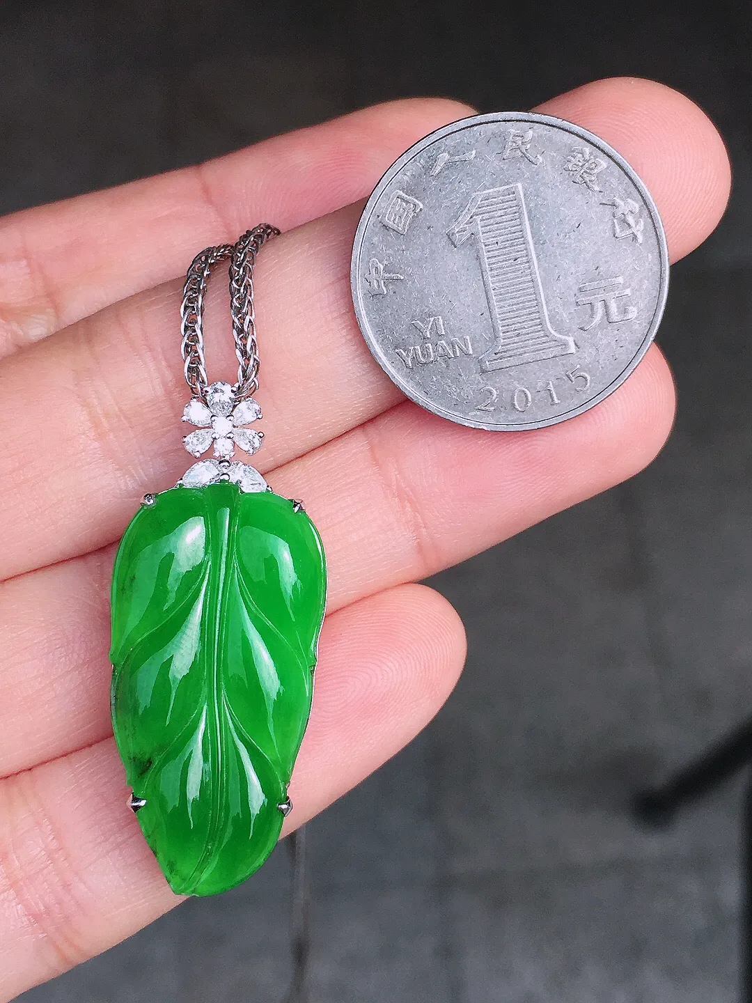 阳绿玉叶吊坠，色泽均匀艳丽，玉质细腻，荧光感超
强，饱满圆润，尽显优雅气质，18k
金豪华镶嵌