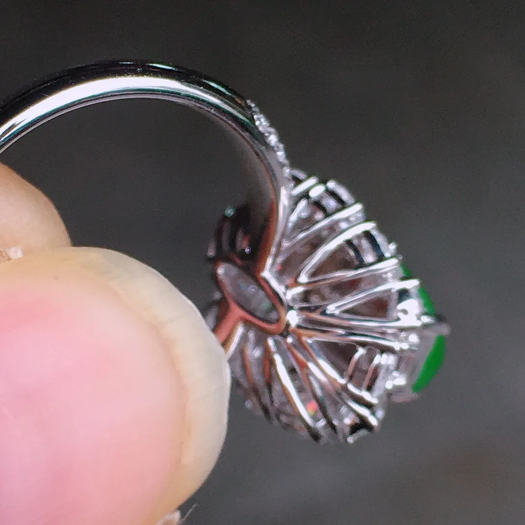 阳绿马鞍戒指，色泽均匀艳丽，玉质细腻，荧光感超
强，饱满圆润，尽显优雅气质，18k
金豪华镶嵌