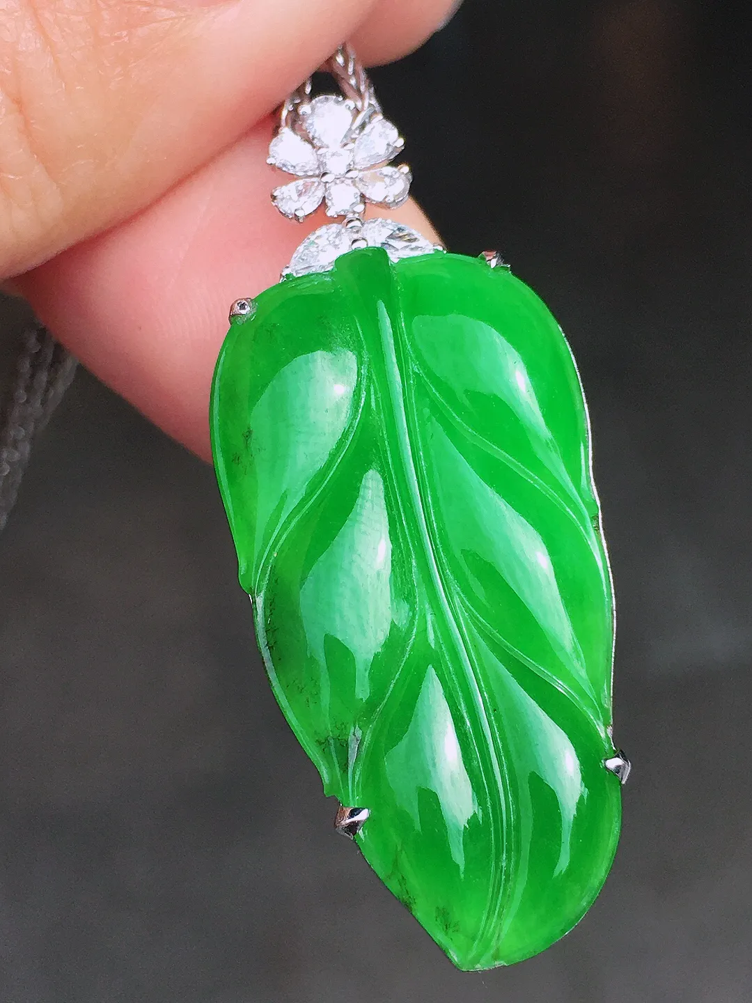 阳绿玉叶吊坠，色泽均匀艳丽，玉质细腻，荧光感超
强，饱满圆润，尽显优雅气质，18k
金豪华镶嵌