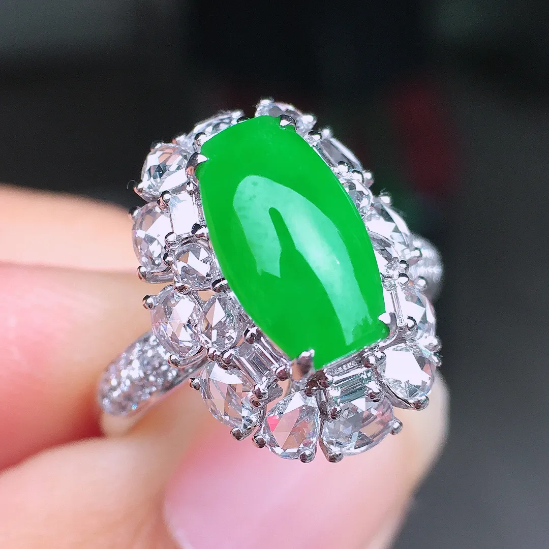 阳绿马鞍戒指，色泽均匀艳丽，玉质细腻，荧光感超
强，饱满圆润，尽显优雅气质，18k
金豪华镶嵌