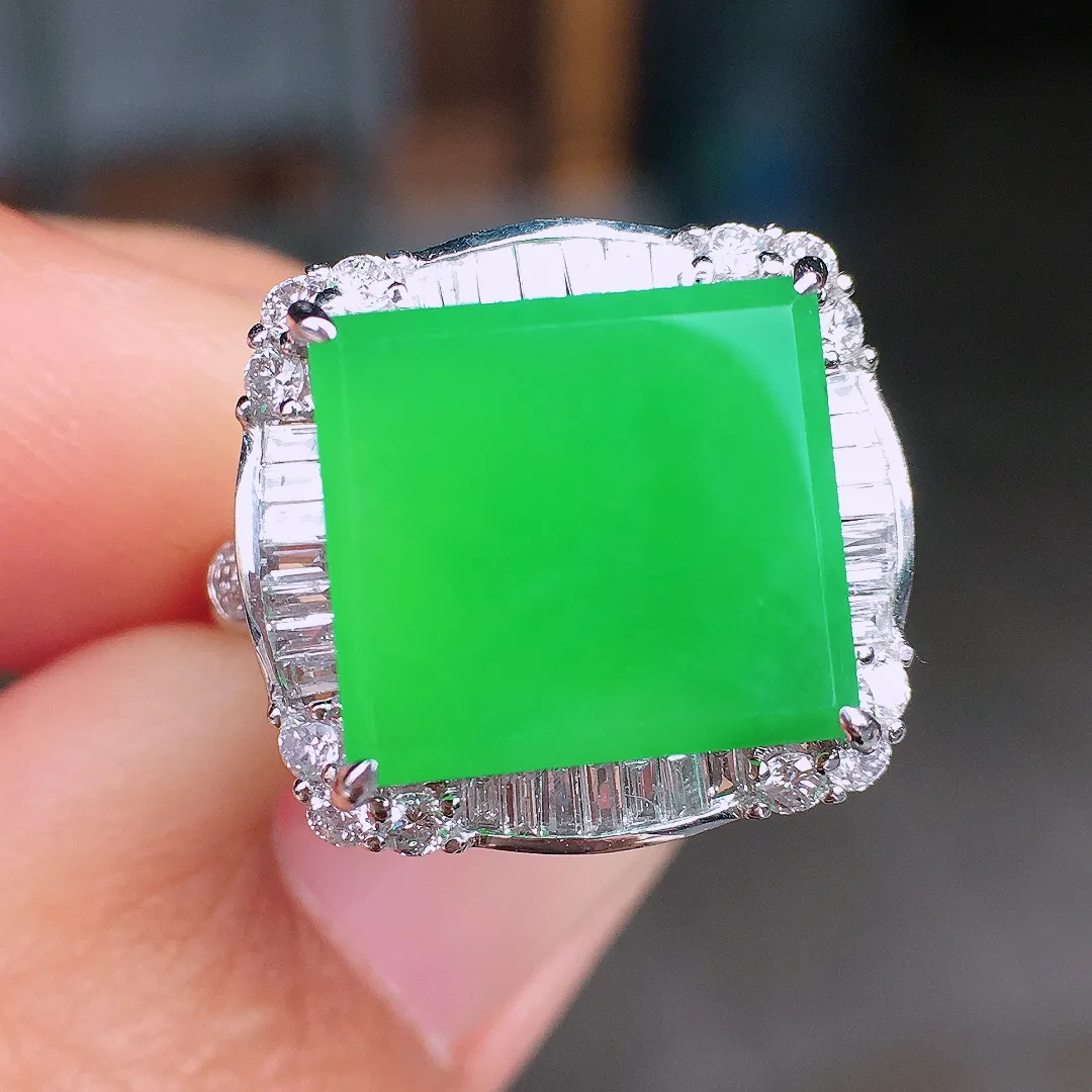 阳绿马鞍戒指，色泽均匀艳丽，玉质细腻，荧光感超
强，饱满圆润，尽显优雅气质，18k
金豪华镶嵌