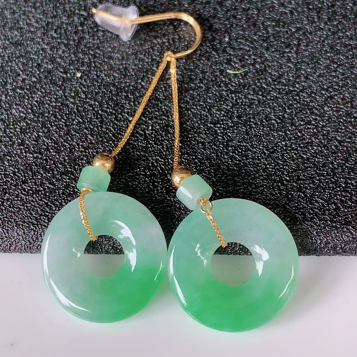 18k金镶嵌冰种飘绿翡翠平安扣耳坠，沁人心脾，耳坠佩戴效果大气出众，尽显气质。种水好，胶感足，颜相当