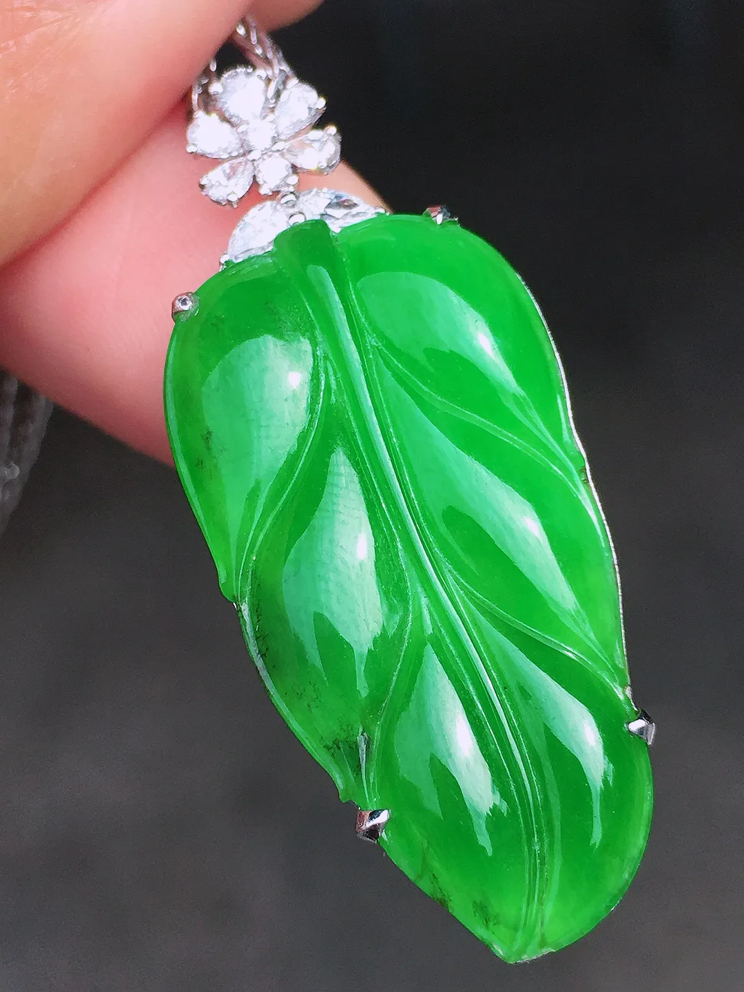 阳绿玉叶吊坠，色泽均匀艳丽，玉质细腻，荧光感超
强，饱满圆润，尽显优雅气质，18k
金豪华镶嵌