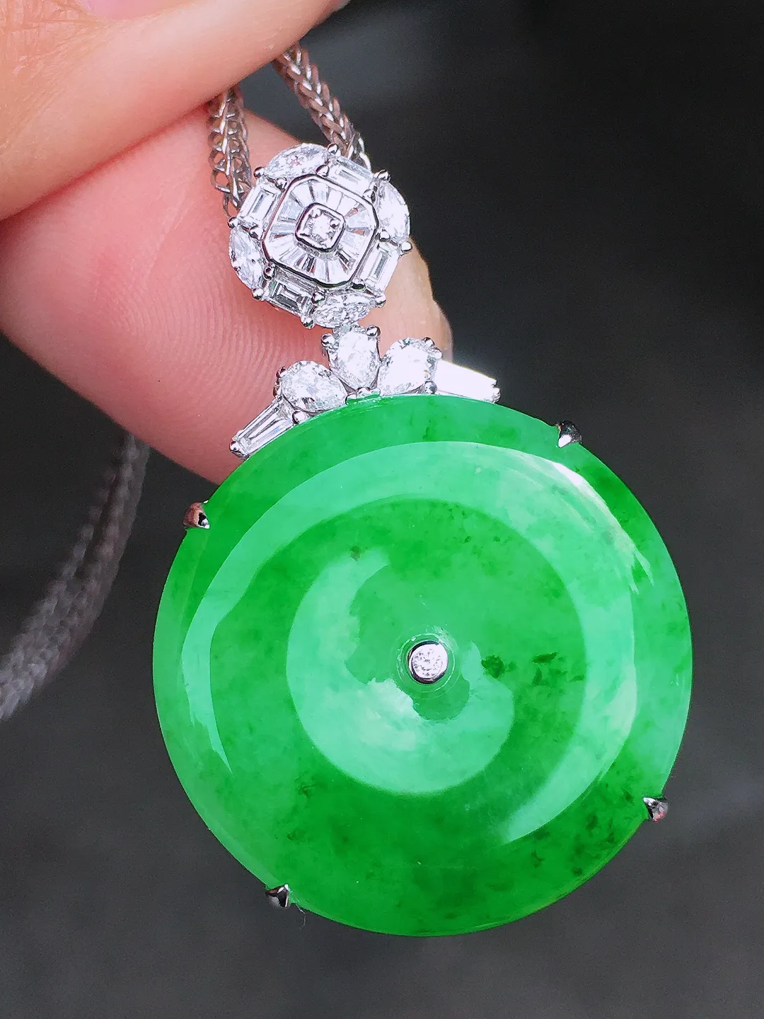 阳绿平安扣吊坠，色泽均匀艳丽，玉质细腻，荧光感超
强，饱满圆润，尽显优雅气质，18k
金豪华镶嵌