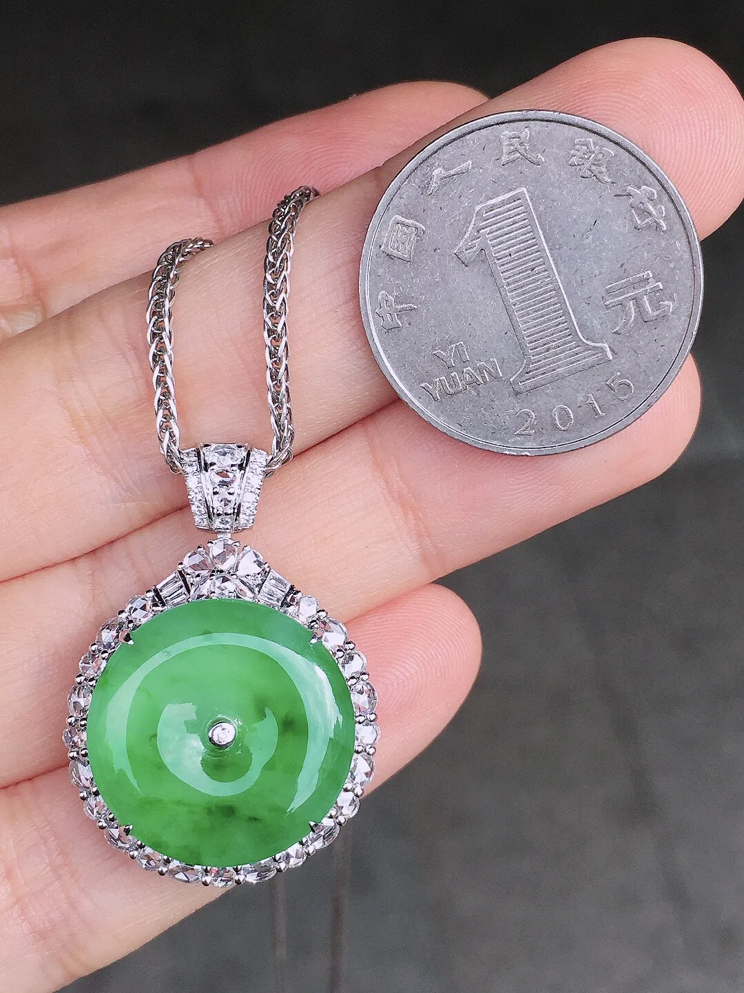 阳绿平安扣吊坠，色泽均匀艳丽，玉质细腻，荧光感超
强，饱满圆润，尽显优雅气质，18k
金豪华镶嵌