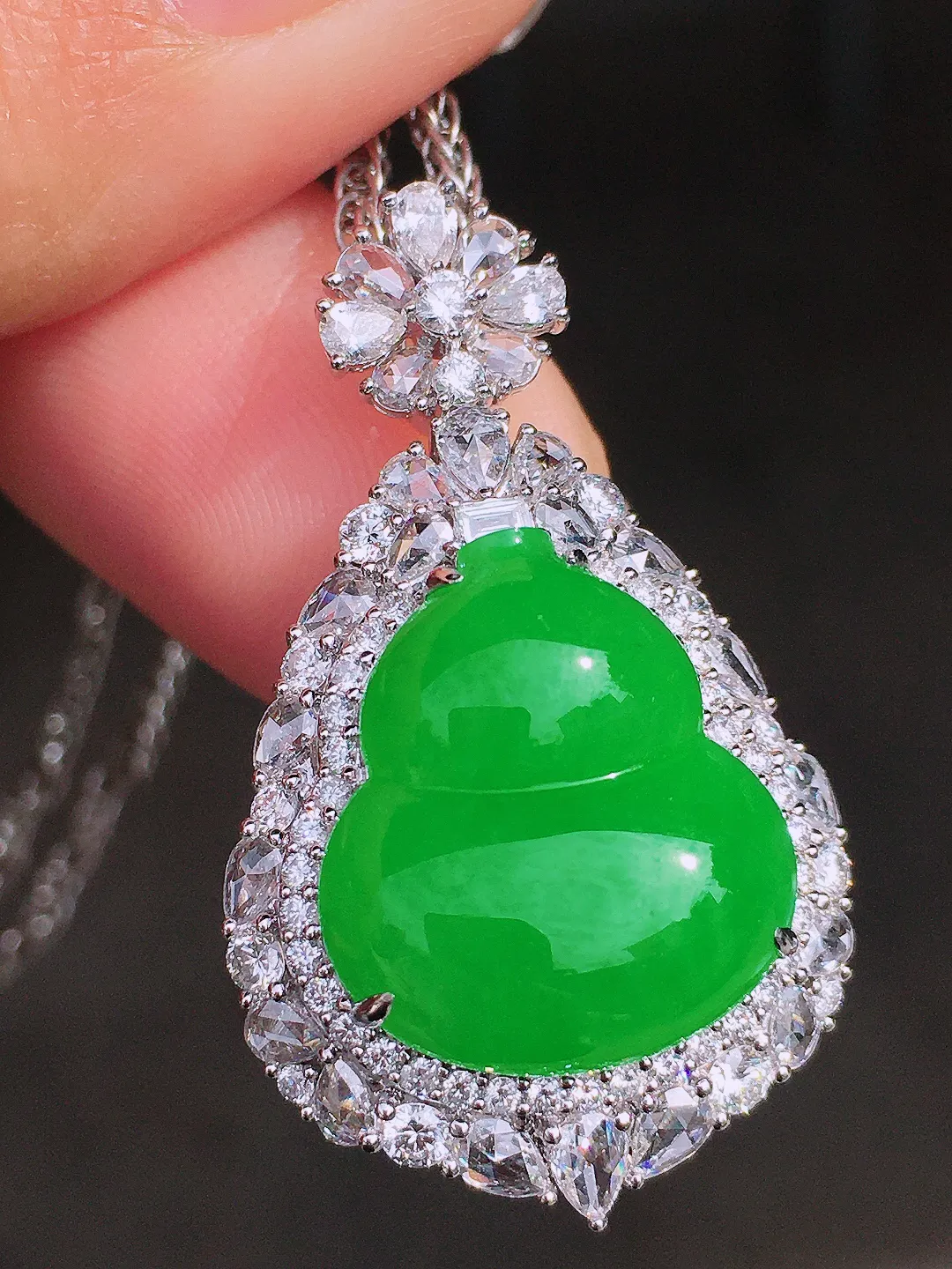 阳绿葫芦吊坠，色泽均匀艳丽，玉质细腻，荧光感超
强，饱满圆润，尽显优雅气质，18k
金豪华镶嵌