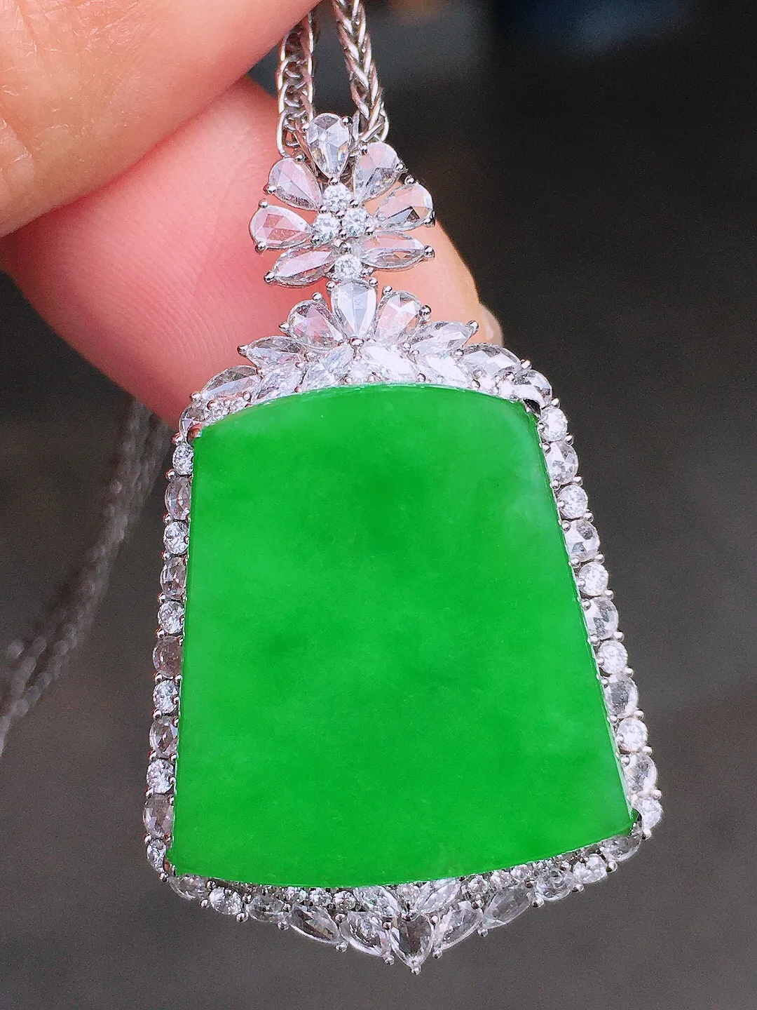 阳绿无事牌吊坠，色泽均匀艳丽，玉质细腻，荧光感超
强，饱满圆润，尽显优雅气质，18k
金豪华镶嵌