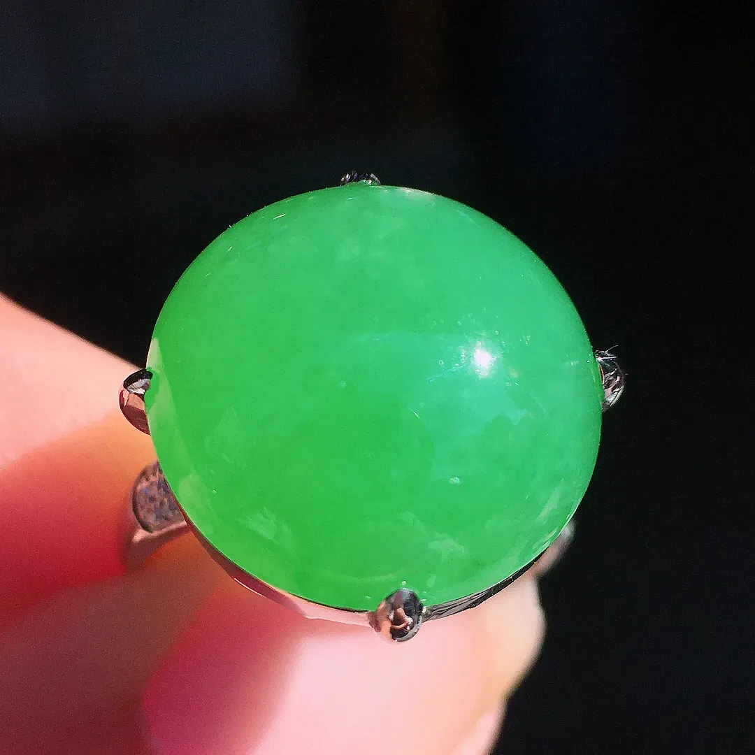 阳绿蛋面戒指，色泽均匀艳丽，玉质细腻，荧光感超
强，饱满圆润，尽显优雅气质，18k
金豪华镶嵌