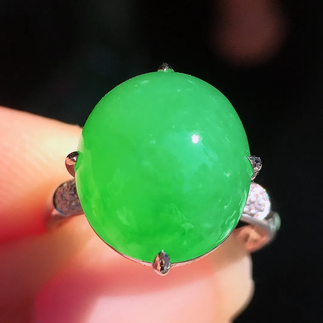 阳绿蛋面戒指，色泽均匀艳丽，玉质细腻，荧光感超
强，饱满圆润，尽显优雅气质，18k
金豪华镶嵌