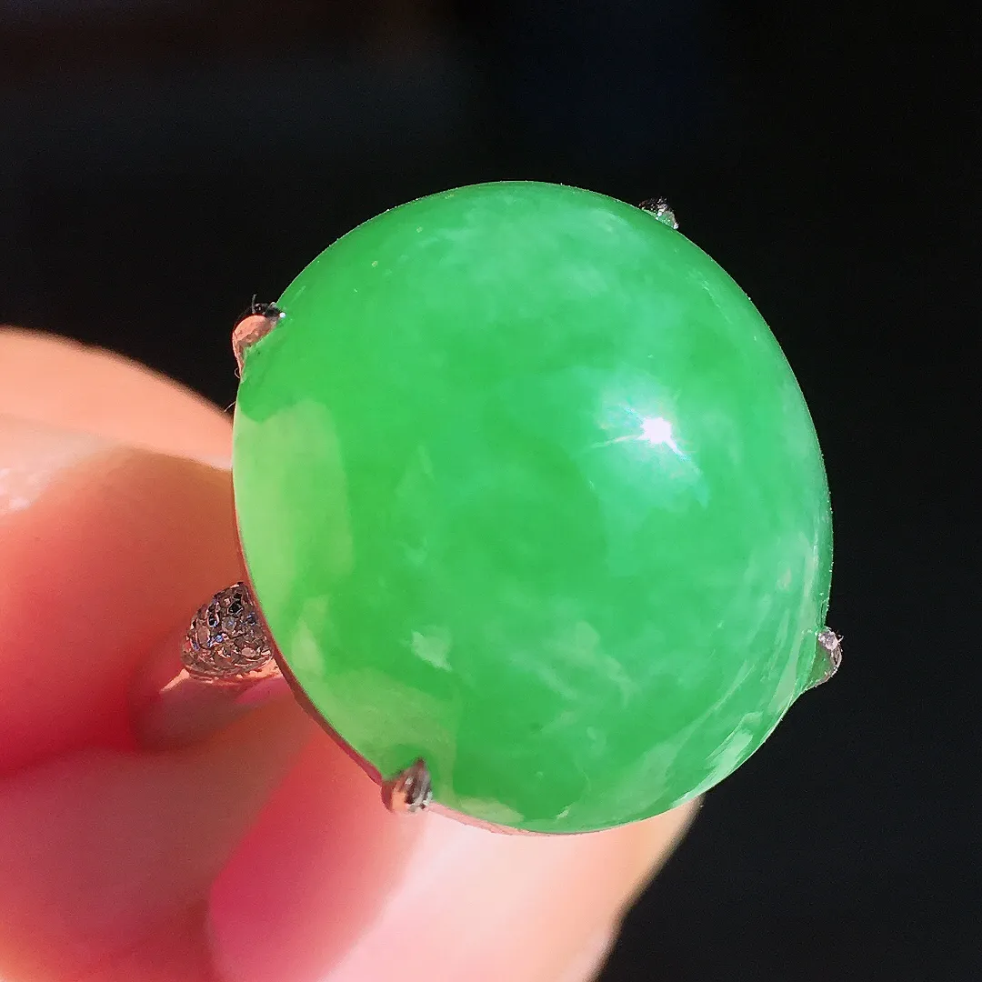 阳绿蛋面戒指，色泽均匀艳丽，玉质细腻，荧光感超
强，饱满圆润，尽显优雅气质，18k
金豪华镶嵌