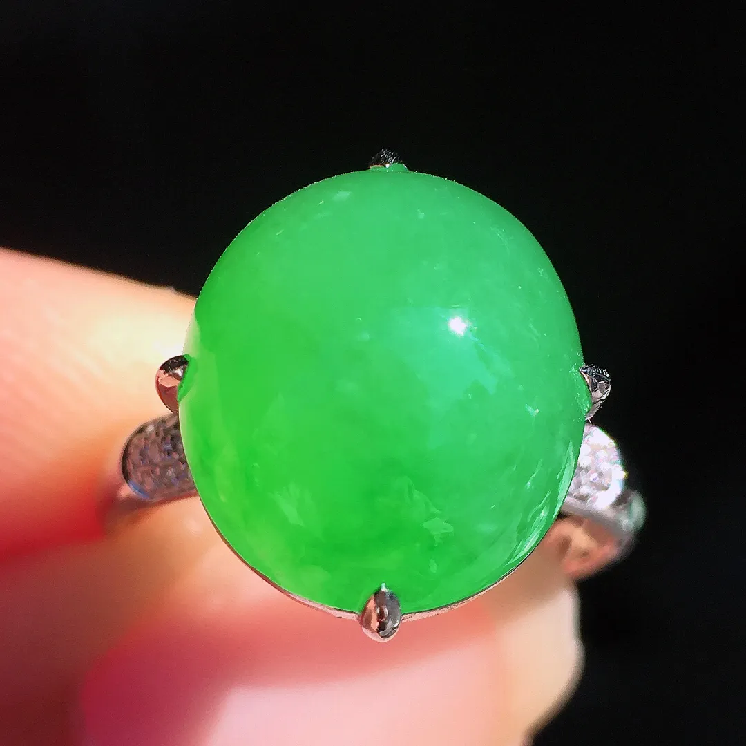 阳绿蛋面戒指，色泽均匀艳丽，玉质细腻，荧光感超
强，饱满圆润，尽显优雅气质，18k
金豪华镶嵌