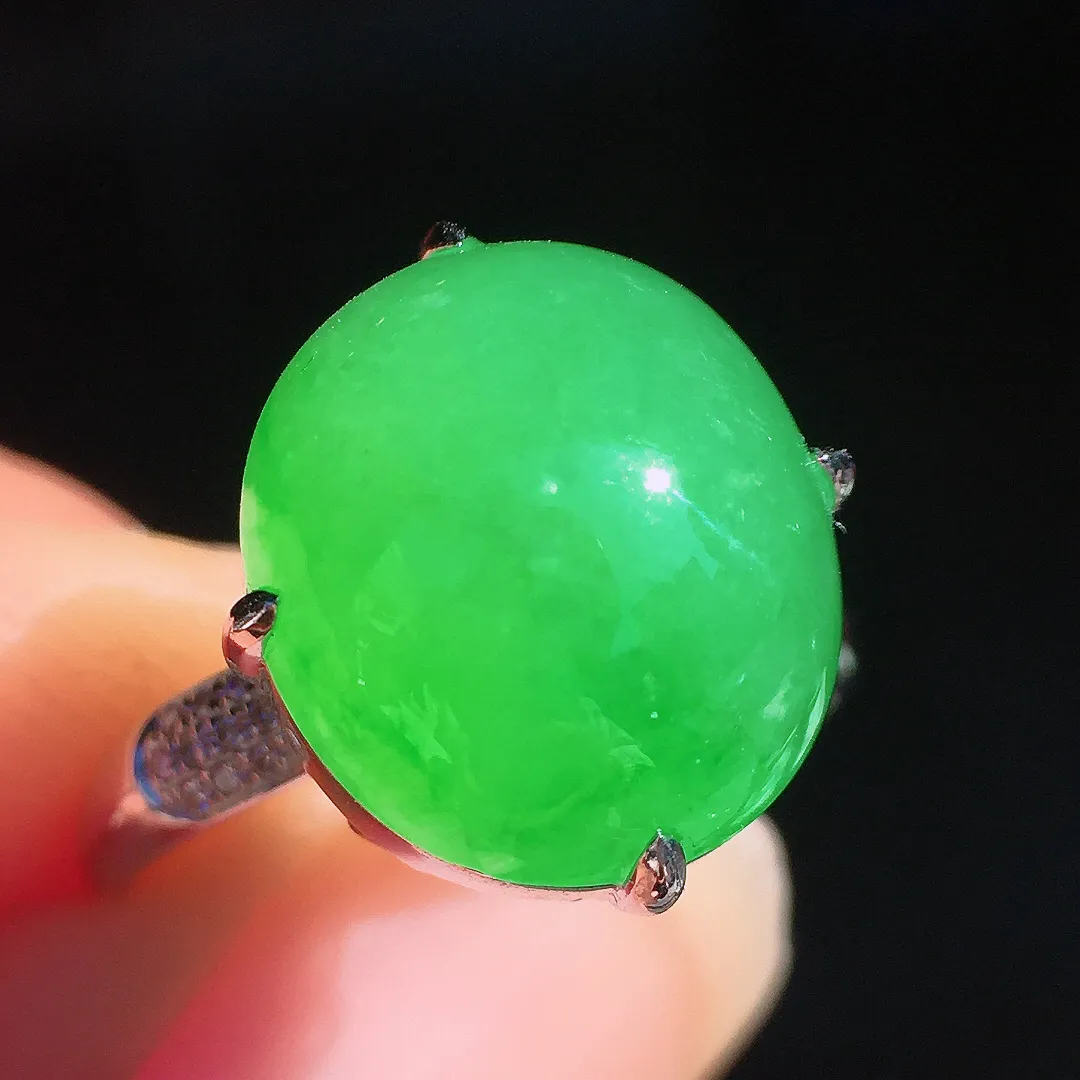 阳绿蛋面戒指，色泽均匀艳丽，玉质细腻，荧光感超
强，饱满圆润，尽显优雅气质，18k
金豪华镶嵌