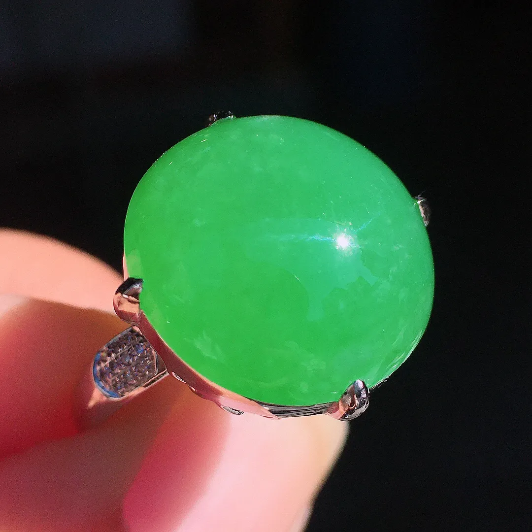 阳绿蛋面戒指，色泽均匀艳丽，玉质细腻，荧光感超
强，饱满圆润，尽显优雅气质，18k
金豪华镶嵌