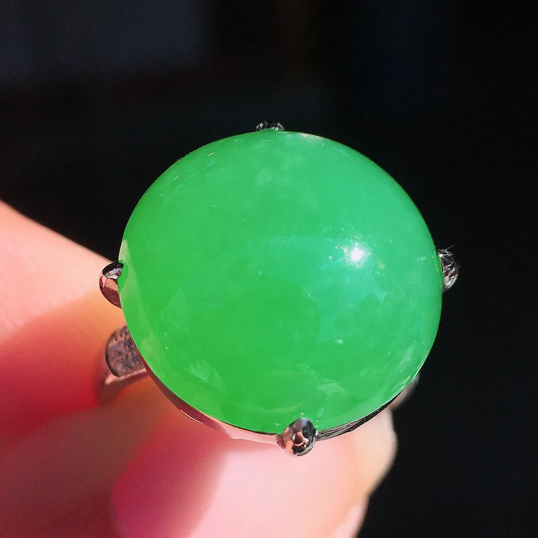 阳绿蛋面戒指，色泽均匀艳丽，玉质细腻，荧光感超
强，饱满圆润，尽显优雅气质，18k
金豪华镶嵌