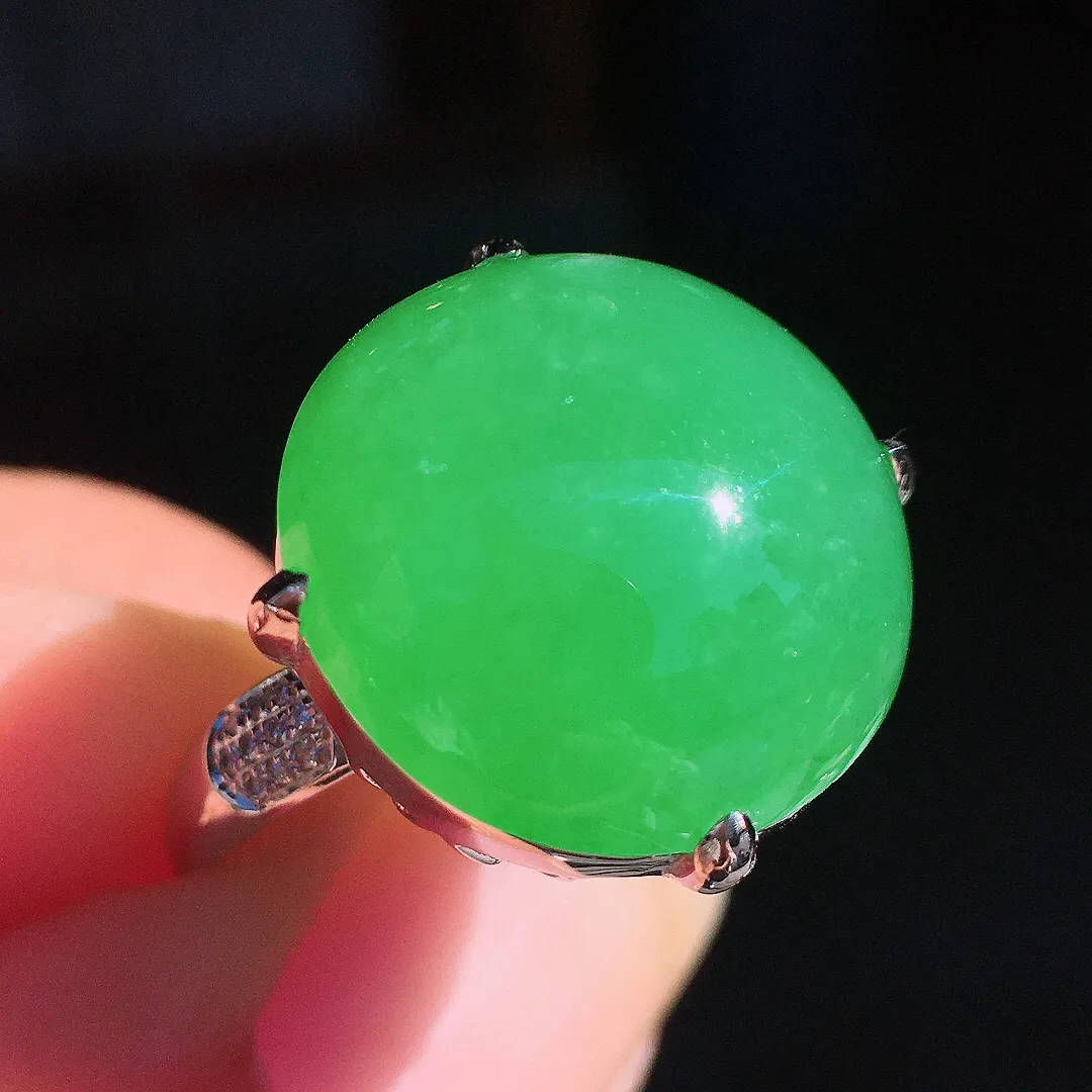 阳绿蛋面戒指，色泽均匀艳丽，玉质细腻，荧光感超
强，饱满圆润，尽显优雅气质，18k
金豪华镶嵌