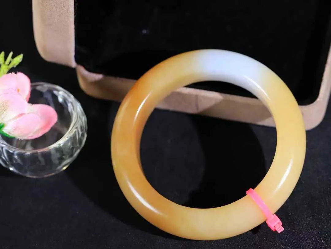 （一见倾心.手镯）

精品和田玉糖白玉手镯，玉质温润细腻 油性十足 手感舒适，高华雅逸，线条流畅，简约大气，美自天成，素雅高贵。佩戴于腕间，婉约之美，举手投足间透出那低调奢华。重81克 尺寸54-15.2-10.5mm161151430T