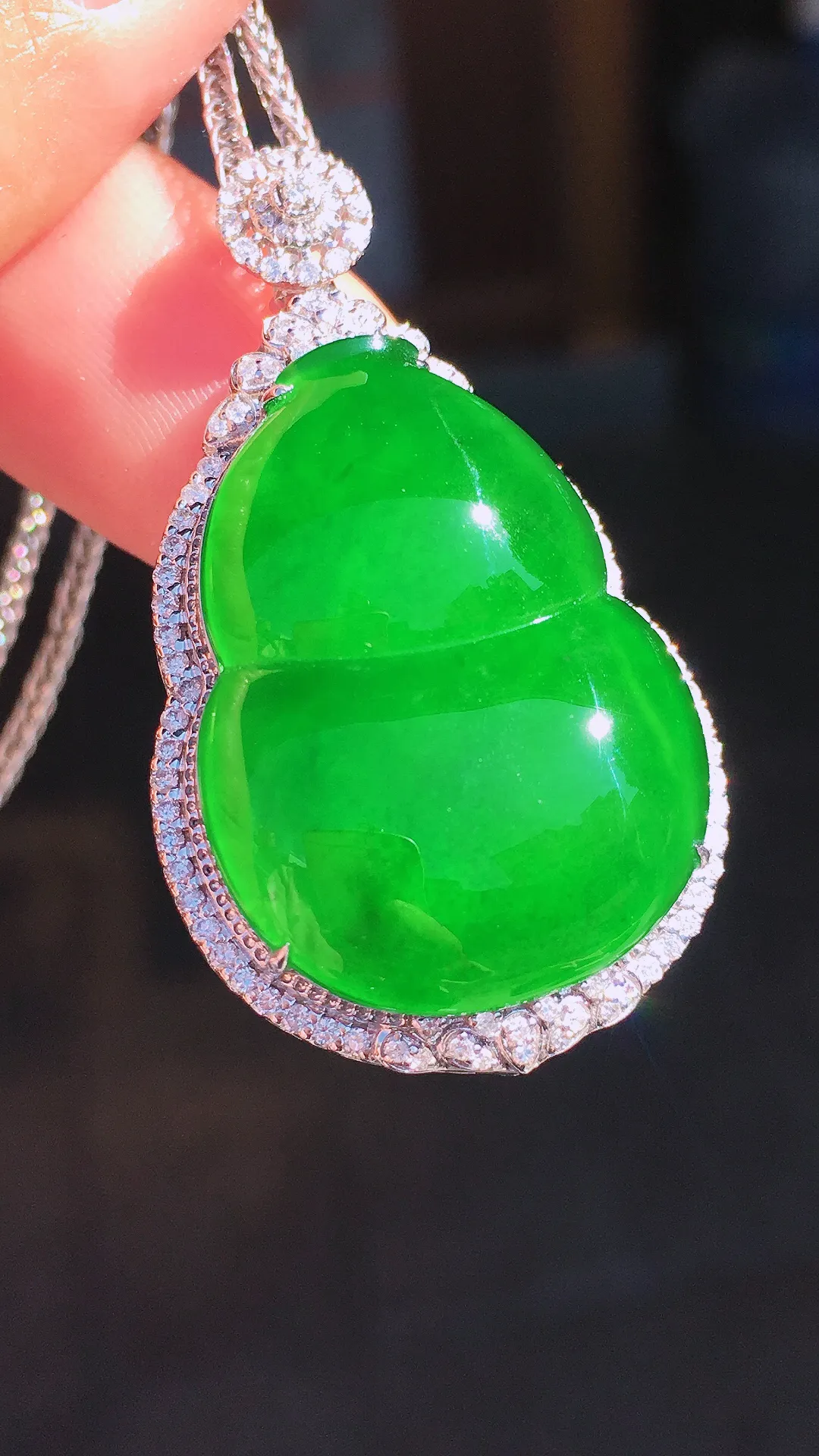 阳绿葫芦吊坠，色泽均匀艳丽，玉质细腻，荧光感超
强，饱满圆润，尽显优雅气质，18k
金豪华镶嵌