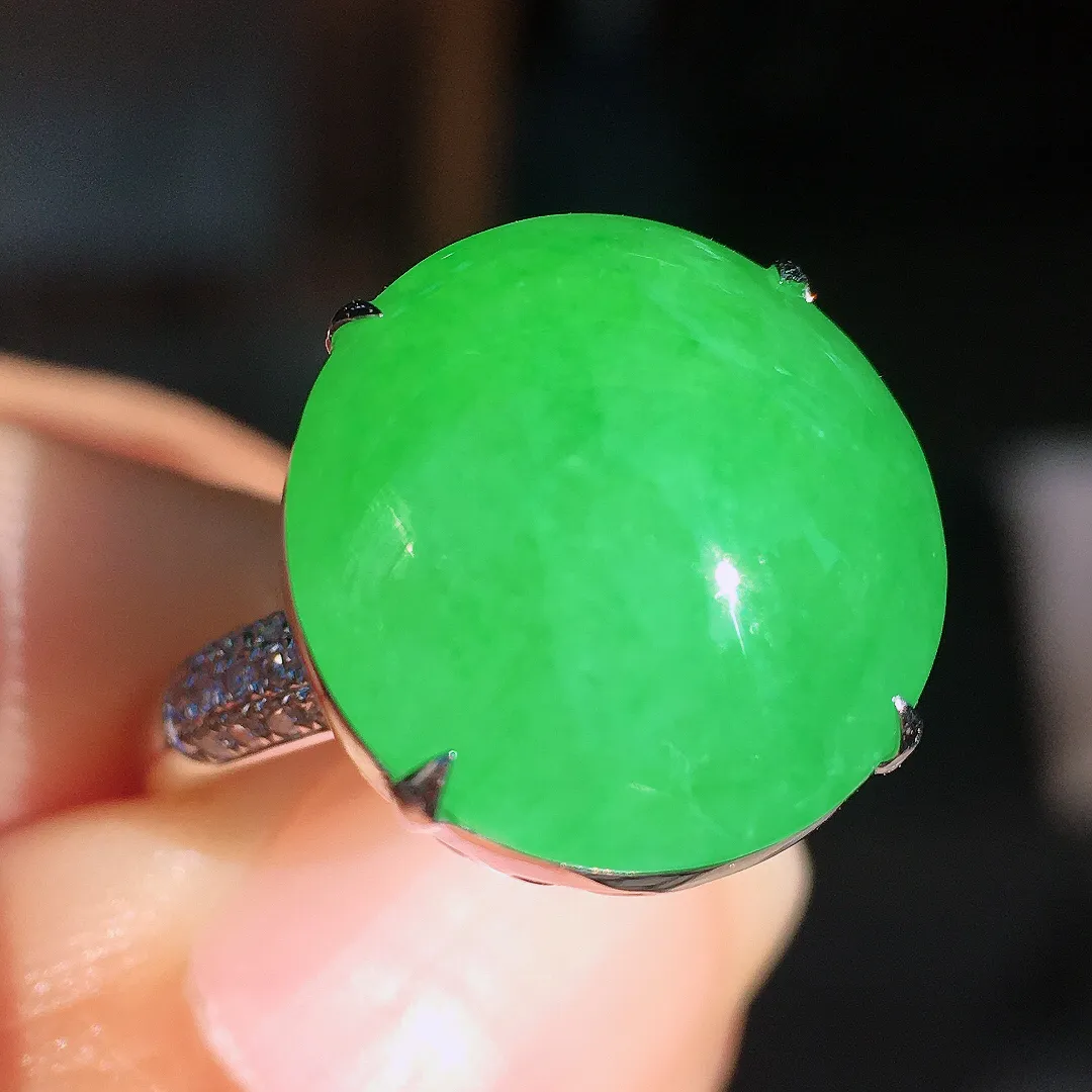 阳绿蛋面戒指，色泽均匀艳丽，玉质细腻，荧光感超
强，饱满圆润，尽显优雅气质，18k
金豪华镶嵌