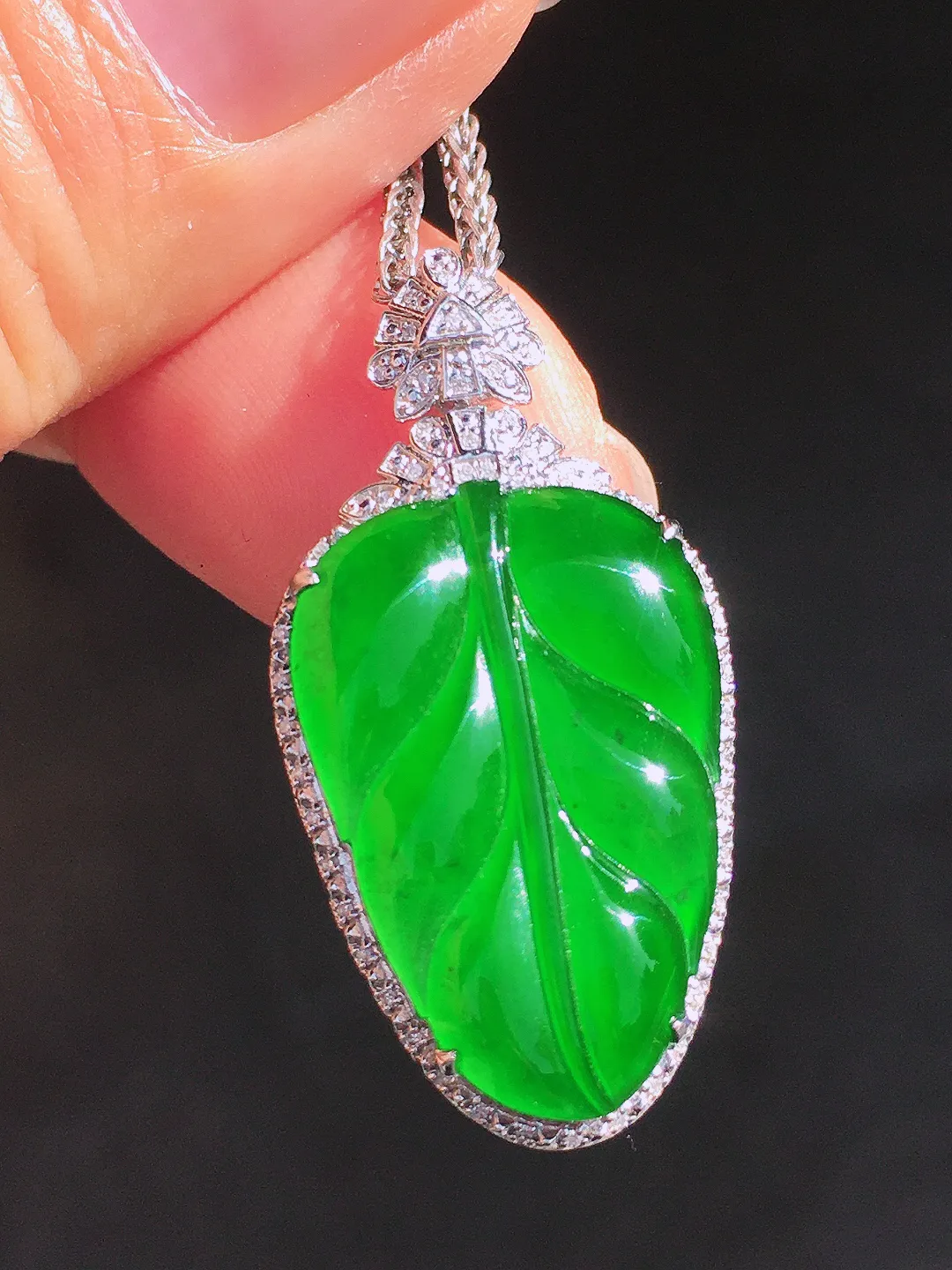 阳绿玉叶吊坠，色泽均匀艳丽，玉质细腻，荧光感超
强，饱满圆润，尽显优雅气质，18k
金豪华镶嵌