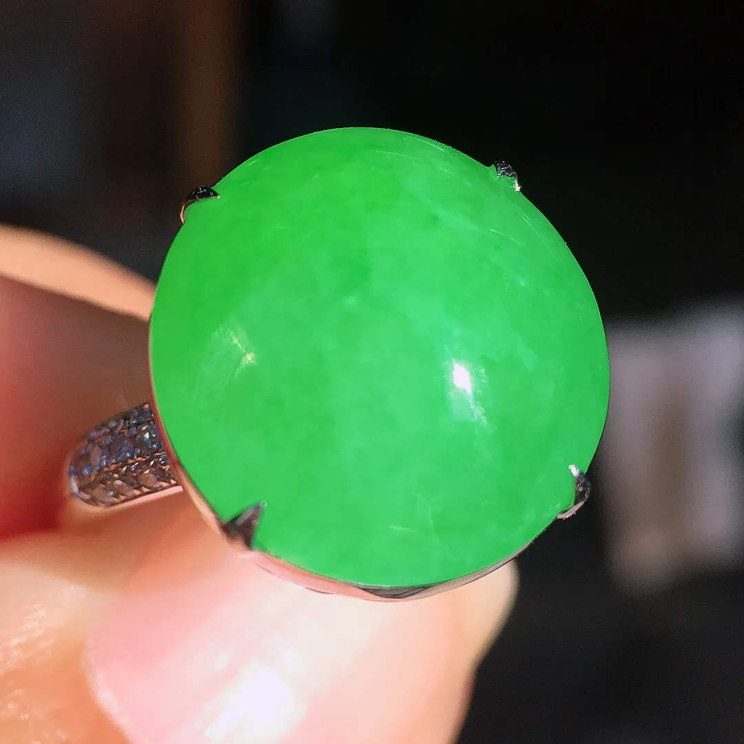 阳绿蛋面戒指，色泽均匀艳丽，玉质细腻，荧光感超
强，饱满圆润，尽显优雅气质，18k
金豪华镶嵌