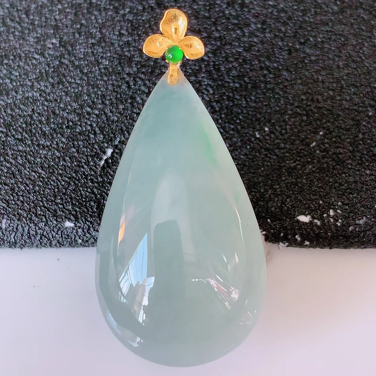 18K金镶嵌冰种飘绿翡翠水滴吊坠，品相佳，颜色漂亮，佩戴时尚优雅，尽显气质。水滴寓意“水滴聚财，坚持不懈，如水爱心” #94.27