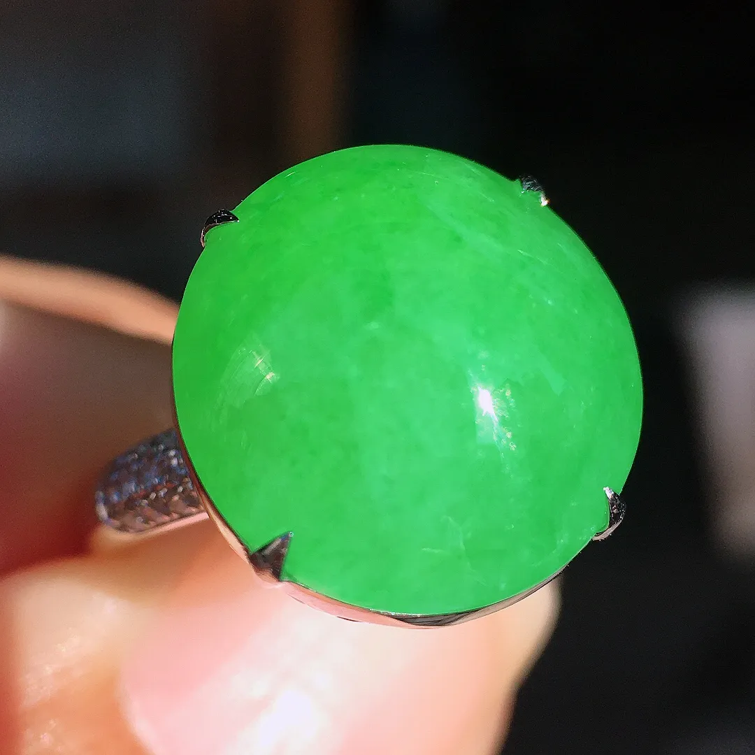 阳绿蛋面戒指，色泽均匀艳丽，玉质细腻，荧光感超
强，饱满圆润，尽显优雅气质，18k
金豪华镶嵌