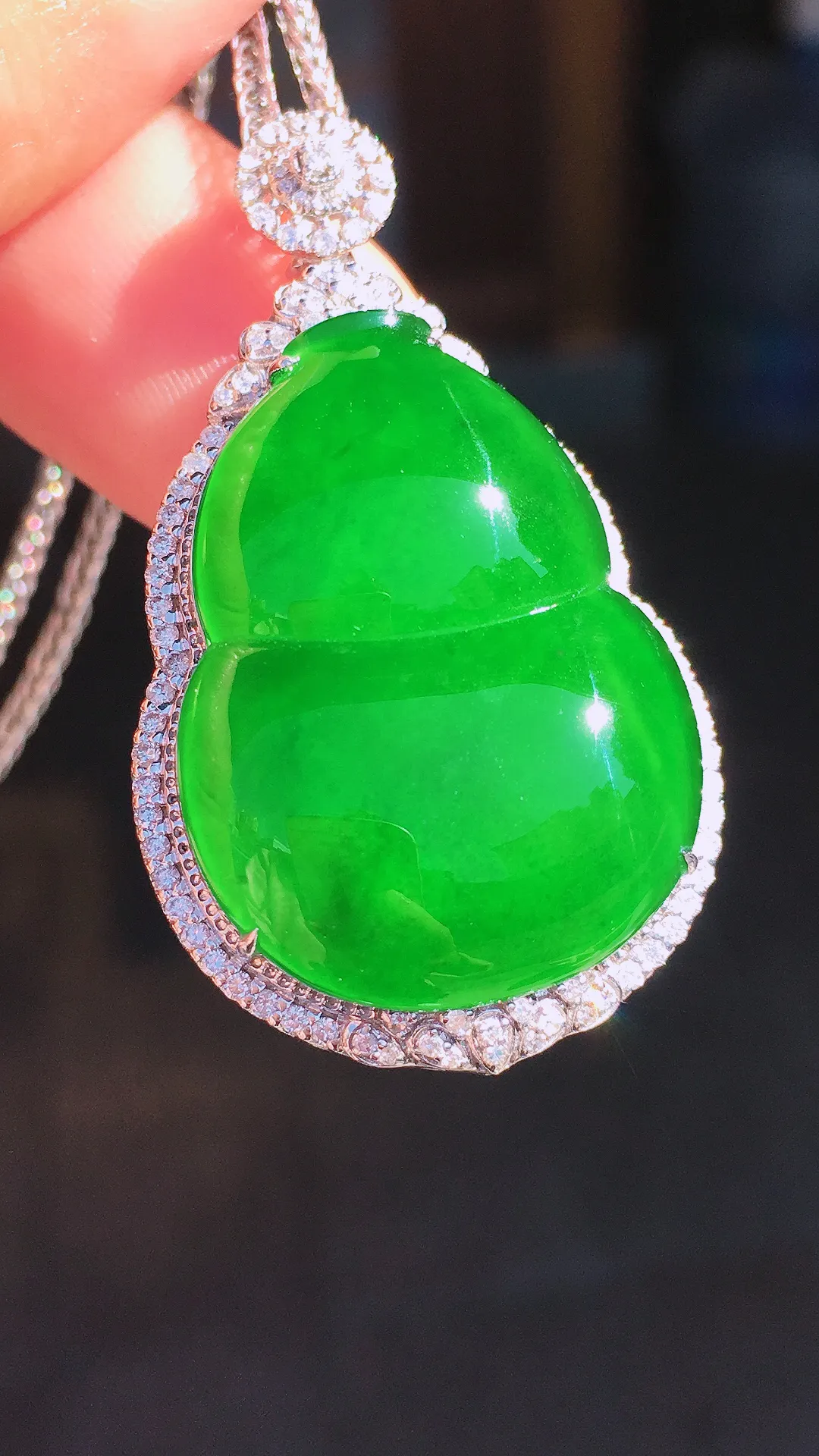 阳绿葫芦吊坠，色泽均匀艳丽，玉质细腻，荧光感超
强，饱满圆润，尽显优雅气质，18k
金豪华镶嵌