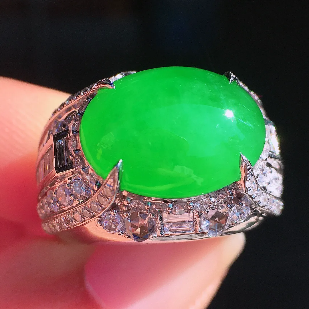 阳绿马鞍戒指，色泽均匀艳丽，玉质细腻，荧光感超
强，饱满圆润，尽显优雅气质，18k
金豪华镶嵌