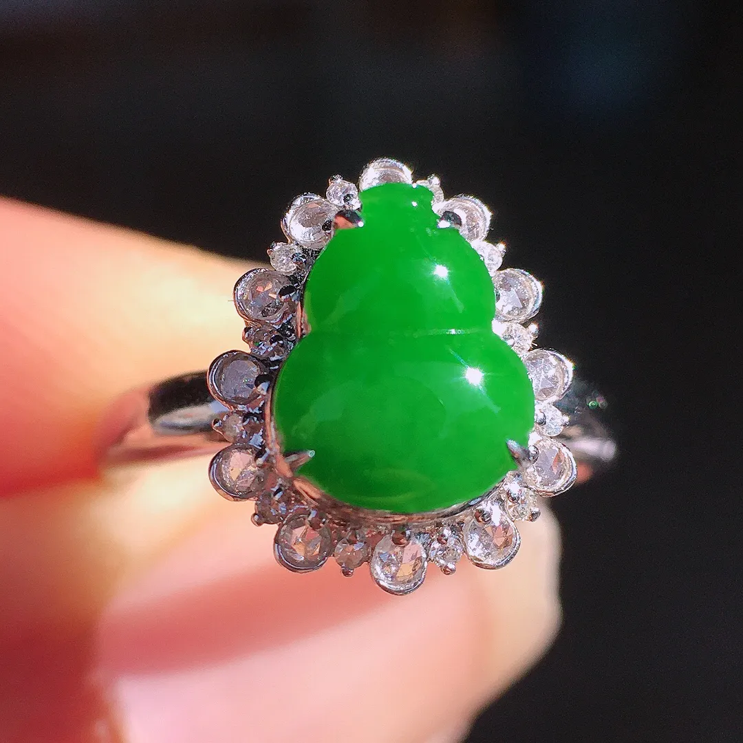 阳绿葫芦戒指，色泽均匀艳丽，玉质细腻，荧光感超
强，饱满圆润，尽显优雅气质，18k
金豪华镶嵌