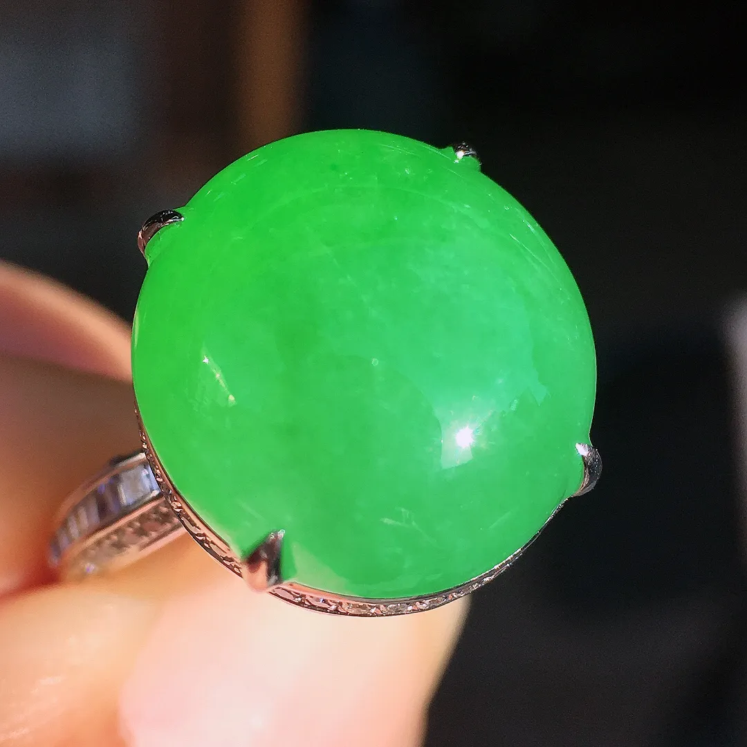 阳绿蛋面戒指，色泽均匀艳丽，玉质细腻，荧光感超
强，饱满圆润，尽显优雅气质，18k
金豪华镶嵌