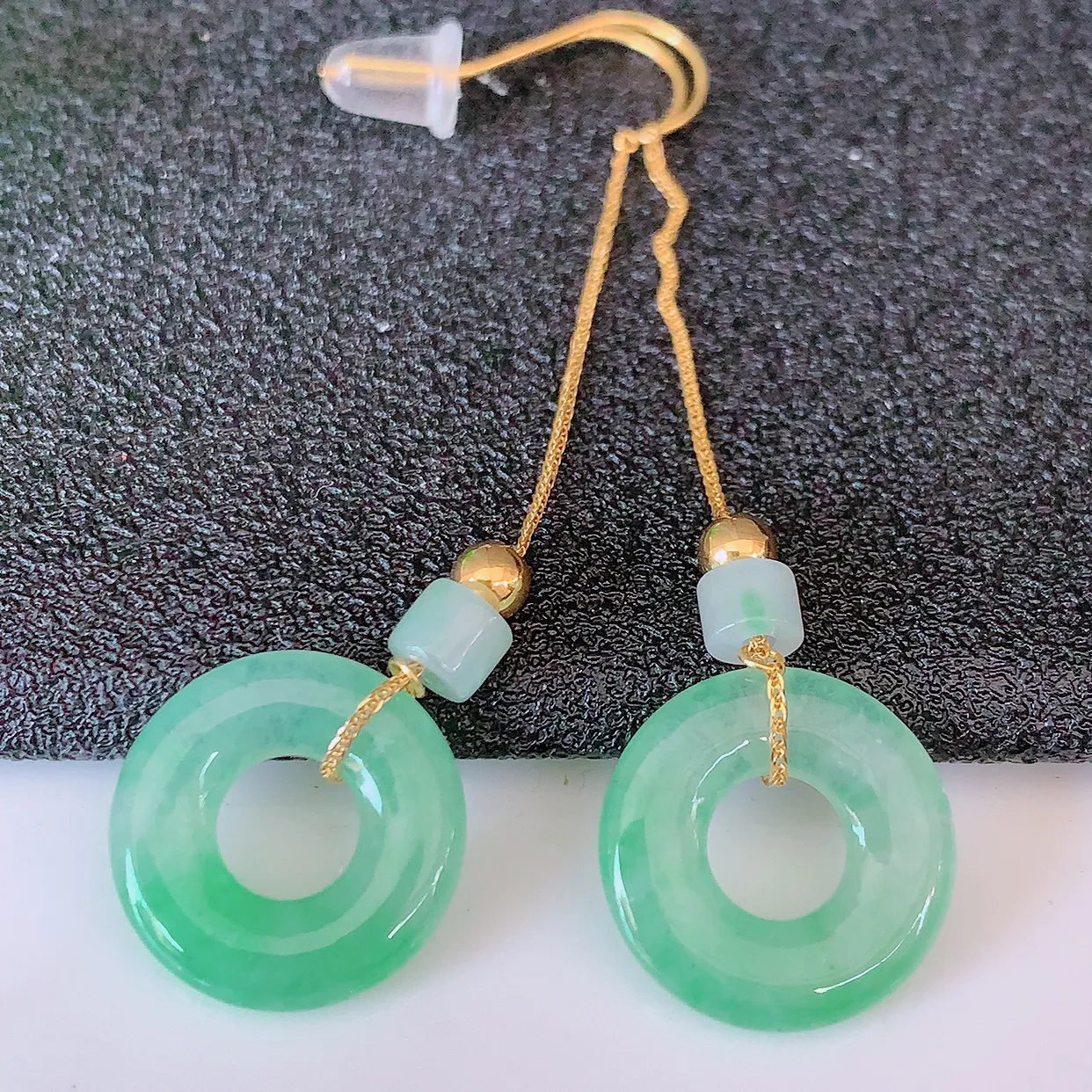 18k金镶嵌冰种飘绿翡翠平安扣耳坠，沁人心脾，耳坠佩戴效果大气出众，尽显气质。种水好，胶感足，颜相当