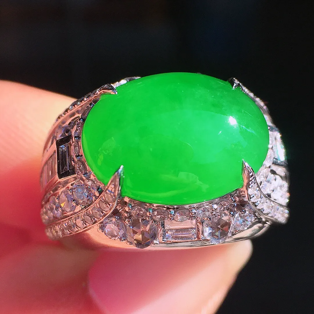 阳绿马鞍戒指，色泽均匀艳丽，玉质细腻，荧光感超
强，饱满圆润，尽显优雅气质，18k
金豪华镶嵌