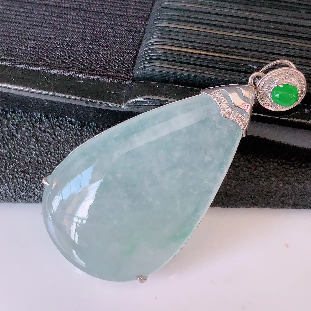 自然光实拍，18K金镶嵌冰种翡翠水滴吊坠，品相佳，颜色漂亮，佩戴时尚优雅，尽显气质。水滴寓意“水滴聚